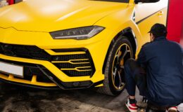 Mechanic checks tire pressure in yellow sport car suv.