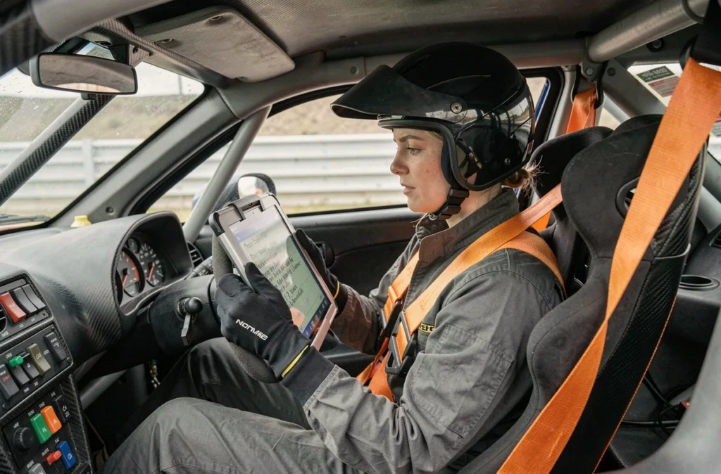 Co-pilote féminine de rally consultant ses notes de pace dans l'habitacle d'une voiture de compétition 2026