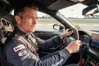 Instructeur de stage de pilotage au volant d'une voiture de sport sur circuit automobile